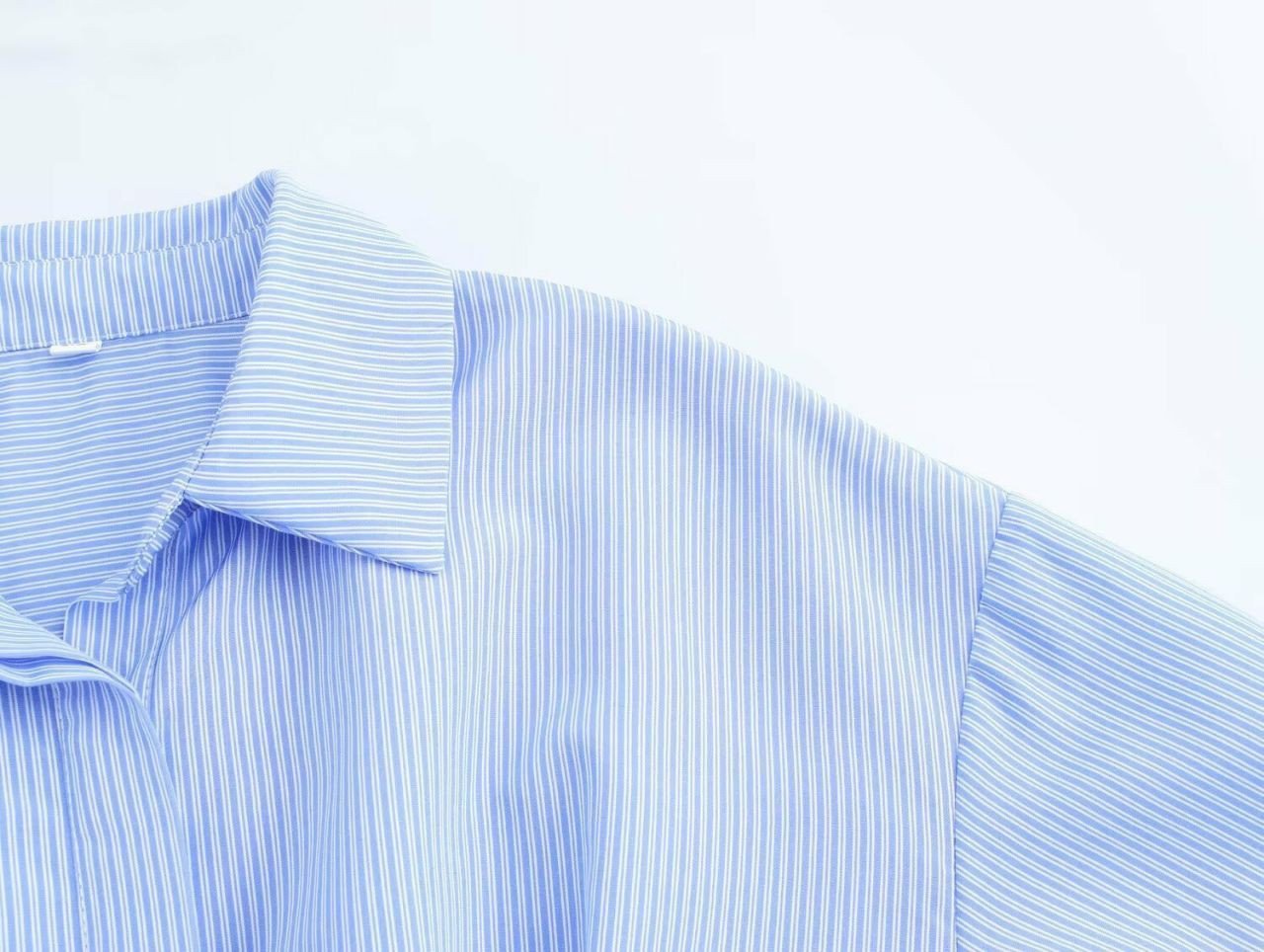 Chemisier élégant court à rayures bleu et blanc avec une ceinture à boucle effet écaille de tortue.